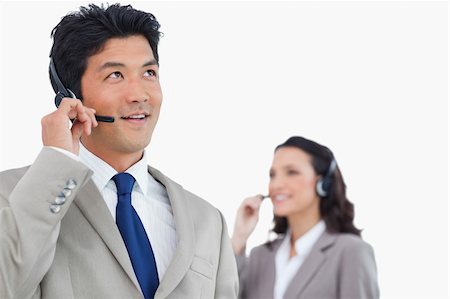 simsearch:400-03933798,k - Call center agent with headset and colleague behind him against a white background Stock Photo - Budget Royalty-Free & Subscription, Code: 400-06685610