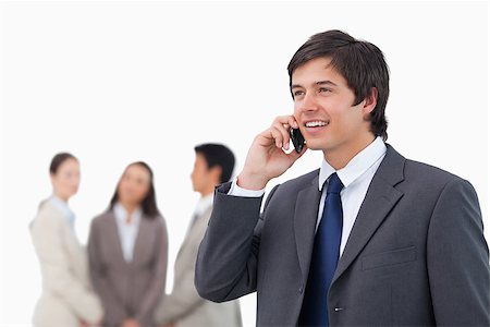 simsearch:859-06710917,k - Salesman talking on cellphone with colleagues behind him against a white background Stock Photo - Budget Royalty-Free & Subscription, Code: 400-06686561