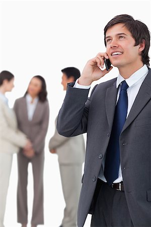 simsearch:859-06710917,k - Salesman talking on mobile phone with team behind him against a white background Stock Photo - Budget Royalty-Free & Subscription, Code: 400-06686562