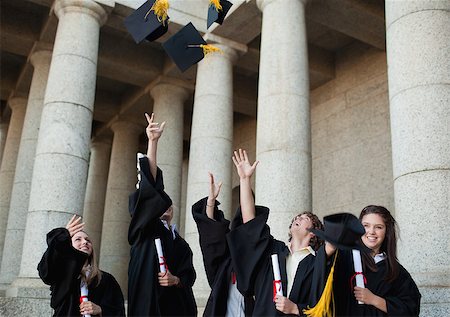 simsearch:400-06688304,k - Happy graduates throwing their hats in the sky in front of their university Photographie de stock - Aubaine LD & Abonnement, Code: 400-06688298