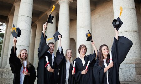 simsearch:400-06688304,k - Smiling graduates holding up their hats in front of the university Photographie de stock - Aubaine LD & Abonnement, Code: 400-06688300