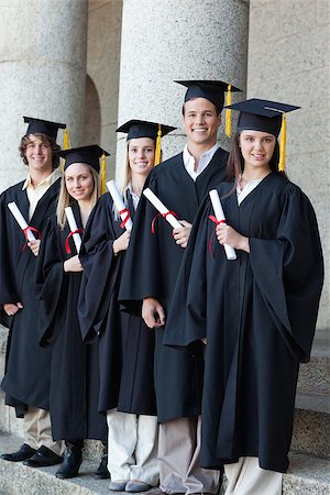 simsearch:400-06688304,k - Happy smiling graduates posing in single line with columns in background Photographie de stock - Aubaine LD & Abonnement, Code: 400-06688398