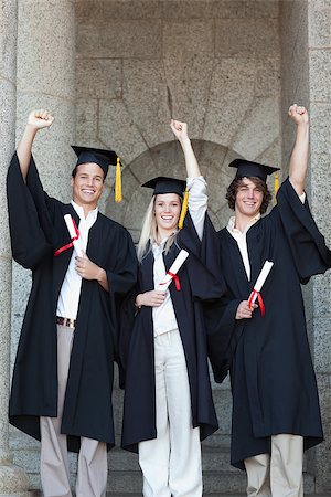 simsearch:400-06688304,k - Happy graduates raising arm with university in backgroung Photographie de stock - Aubaine LD & Abonnement, Code: 400-06688391