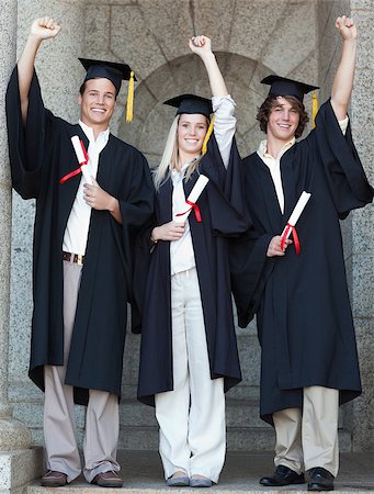 simsearch:400-06688304,k - Smiling graduates raising arm with university in backgroung Photographie de stock - Aubaine LD & Abonnement, Code: 400-06688392