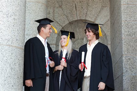 simsearch:400-06688304,k - Happy graduates speaking together with university in backgroung Photographie de stock - Aubaine LD & Abonnement, Code: 400-06688393