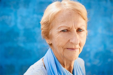 diego_cervo (artist) - Senior people portrait, happy old blonde woman in blu clothes smiling and looking at camera against blue wall Stock Photo - Budget Royalty-Free & Subscription, Code: 400-06694835