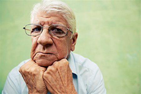 simsearch:400-06142278,k - people and emotions, portrait of depressed senior hispanic man with glasses looking at camera, leaning with hands on chin. Copy space Stock Photo - Budget Royalty-Free & Subscription, Code: 400-06694842