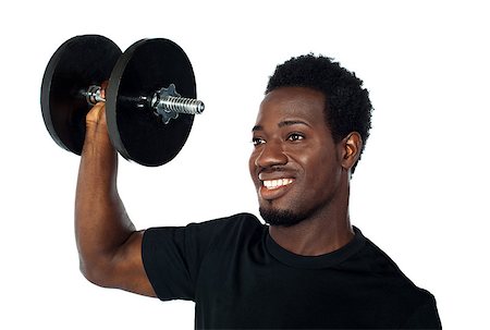 simsearch:400-06859193,k - Powerful muscular young man lifting weights. Smiling and looking away Stock Photo - Budget Royalty-Free & Subscription, Code: 400-06699823