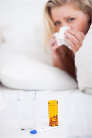 Medicines with a blonde woman sneezing in her bed in background Stock Photo - Budget Royalty-Free & Subscription, Code: 400-06691386