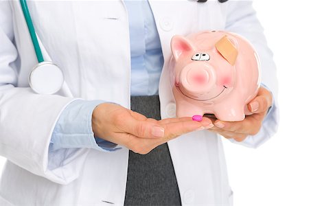 Closeup on medical doctor woman giving pills to piggy bank Stock Photo - Budget Royalty-Free & Subscription, Code: 400-06701183