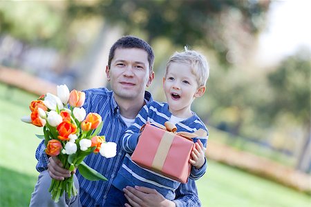 handsome young man and child offering a gift and flowers Stock Photo - Budget Royalty-Free & Subscription, Code: 400-06701372