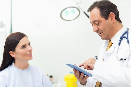 Doctor talking with a patient while using a tablet in an examination room Stock Photo - Budget Royalty-Free & Subscription, Code: 400-06734174