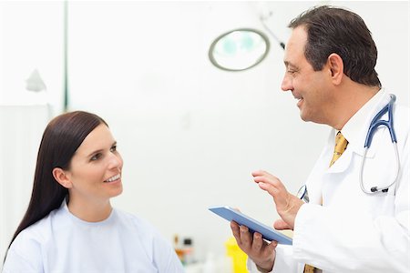 Doctor talking to a patient while holding a tablet tactile in an examination room Stock Photo - Budget Royalty-Free & Subscription, Code: 400-06734175