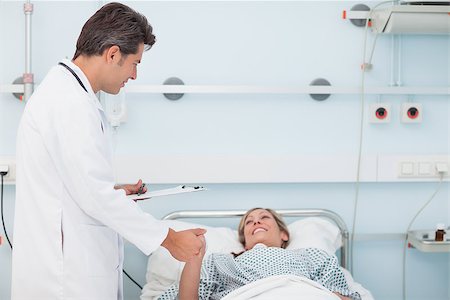 Doctor looking at his patient while holding her hand in hospital ward Stock Photo - Budget Royalty-Free & Subscription, Code: 400-06734187