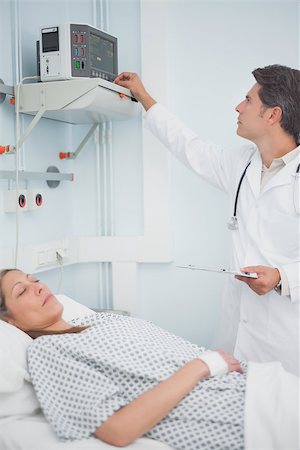 Doctor adjusting a monitor in hospital ward Stock Photo - Budget Royalty-Free & Subscription, Code: 400-06734190