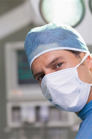 simsearch:400-06734297,k - Serious doctor looking at camera in operating theater Stock Photo - Budget Royalty-Free & Subscription, Code: 400-06734298