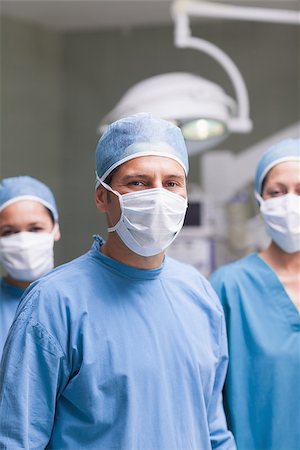 simsearch:400-06734297,k - Medical team wearing mask and cap in operating theatre Stock Photo - Budget Royalty-Free & Subscription, Code: 400-06734291
