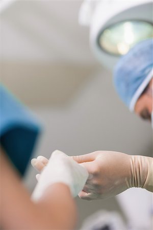 simsearch:400-06734297,k - Close up of a nurse giving a surgical scissor to a doctor in operating theater Stock Photo - Budget Royalty-Free & Subscription, Code: 400-06734310