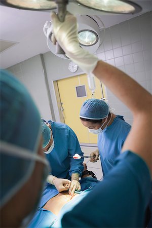 simsearch:400-06734297,k - Nurse illuminating the operating table in operating theater Stock Photo - Budget Royalty-Free & Subscription, Code: 400-06734514