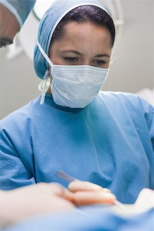 simsearch:400-06734297,k - Doctor operating a patient in operating theater Stock Photo - Budget Royalty-Free & Subscription, Code: 400-06734525
