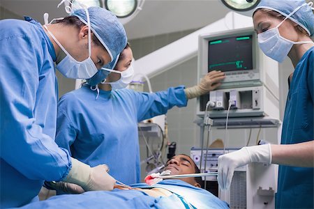 simsearch:400-06734297,k - Doctors operating a patient in operating theater Stock Photo - Budget Royalty-Free & Subscription, Code: 400-06734520