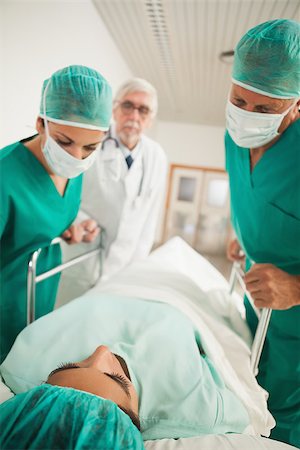 Patient lying on a medical bed next to doctors in hospital corridor Stock Photo - Budget Royalty-Free & Subscription, Code: 400-06734617