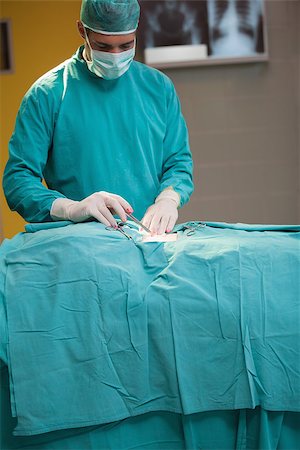 simsearch:400-06734297,k - Surgeon operating a patient in operating theater Stock Photo - Budget Royalty-Free & Subscription, Code: 400-06734675