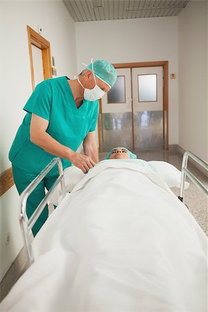 Patient lying on a medical bed next to a surgeon in hospital corridor Stock Photo - Budget Royalty-Free & Subscription, Code: 400-06734781