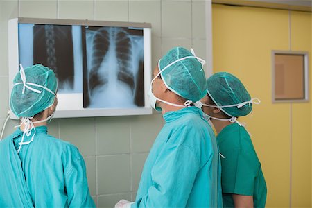 Medical team looking at a X-ray in operating theater Stock Photo - Budget Royalty-Free & Subscription, Code: 400-06734904