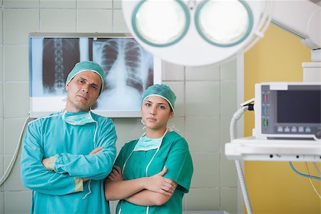 simsearch:400-06734297,k - Serious surgeon and a nurse looking at camera in operating theater Stock Photo - Budget Royalty-Free & Subscription, Code: 400-06734909