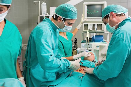 Surgeons operating with surgical tools in an operating theatre Stock Photo - Budget Royalty-Free & Subscription, Code: 400-06735476