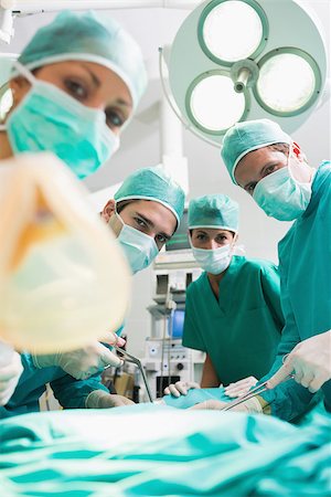 Surgeons and nurses looking at camera in an operating theatre Stock Photo - Budget Royalty-Free & Subscription, Code: 400-06735488