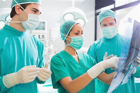 Surgical team analysing a X-ray in an operating theatre Stock Photo - Budget Royalty-Free & Subscription, Code: 400-06735529
