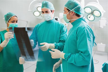 Close up of a surgical team talking about a X-ray in an operating theatre Stock Photo - Budget Royalty-Free & Subscription, Code: 400-06735537
