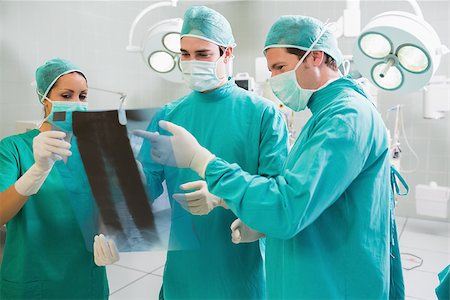 Close up of a surgical team analysing a X-ray in an operating theatre Stock Photo - Budget Royalty-Free & Subscription, Code: 400-06735538