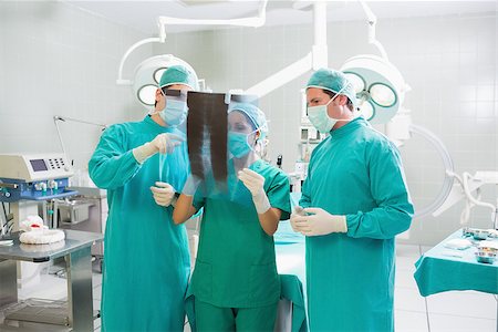 Surgical team talking about a X-ray in an operating theatre Stock Photo - Budget Royalty-Free & Subscription, Code: 400-06735531