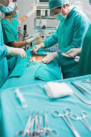 Focus on surgical team next to surgical tools in an operating theatre Stock Photo - Budget Royalty-Free & Subscription, Code: 400-06735544