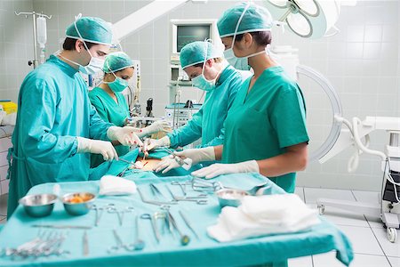 Side view of a surgical team operating a patient in an operation theatre Stock Photo - Budget Royalty-Free & Subscription, Code: 400-06735540