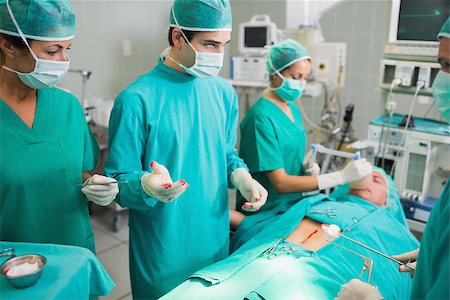 Surgeons standing next to a patient in an operating theatre Stock Photo - Budget Royalty-Free & Subscription, Code: 400-06735563