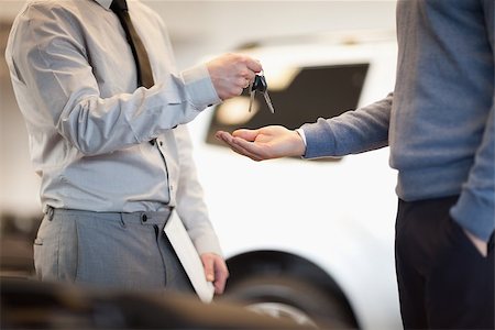 Man giving keys to another man in a car shop Stock Photo - Budget Royalty-Free & Subscription, Code: 400-06733652