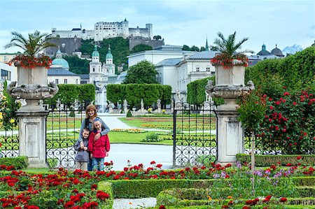 Family in summer Gardens of Mirabell Palace with red rose flowerbeds  and Hohensalzburg Fortress behind (Salzburg, Austria). All people behind are not unidentified. Stock Photo - Budget Royalty-Free & Subscription, Code: 400-06741644