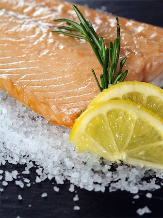 Photo of a cooked salmon steak with rosemary and lemon slices on a bed of sea salt. Stock Photo - Budget Royalty-Free & Subscription, Code: 400-06743347