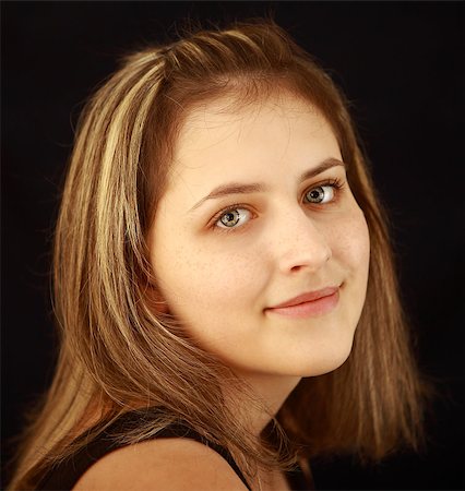 One girl teenager, aged 17, a natural beauty, smile, freckles on his face, gray eyes, brown hair with highlights, close-up portrait on black background. Stock Photo - Budget Royalty-Free & Subscription, Code: 400-06759920