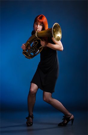 picture of the blue playing a instruments - girl in black dress with trumpet, blue background Stock Photo - Budget Royalty-Free & Subscription, Code: 400-06761978