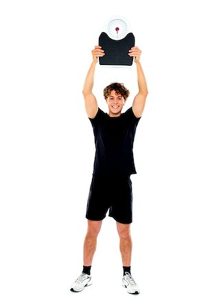 simsearch:400-06482604,k - Male athlete standing and showing weighing machine against white background Stock Photo - Budget Royalty-Free & Subscription, Code: 400-06770833