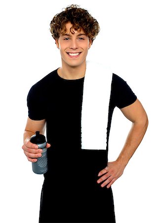 simsearch:400-06482604,k - Young athletic smiling guy holding sports bottle with towel on shoulders Stock Photo - Budget Royalty-Free & Subscription, Code: 400-06795501