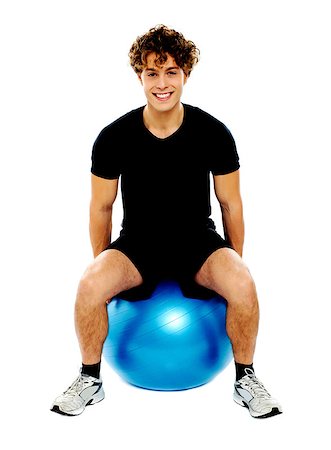 simsearch:400-06482604,k - Handsome guy seated on exercise ball over white background Stock Photo - Budget Royalty-Free & Subscription, Code: 400-06795511