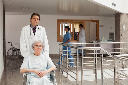 Doctor pushing elderly woman in a wheelchair Stock Photo - Budget Royalty-Free & Subscription, Code: 400-06799492