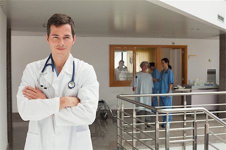 Smiling doctor standing in the hallway of a hospital while crossing his arms Stock Photo - Budget Royalty-Free & Subscription, Code: 400-06799507