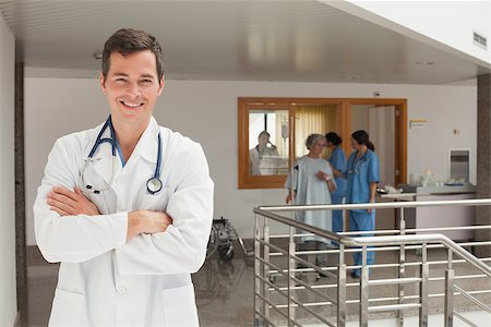 Laughing doctor standing in the hallway while crossing his arms Stock Photo - Budget Royalty-Free & Subscription, Code: 400-06799508